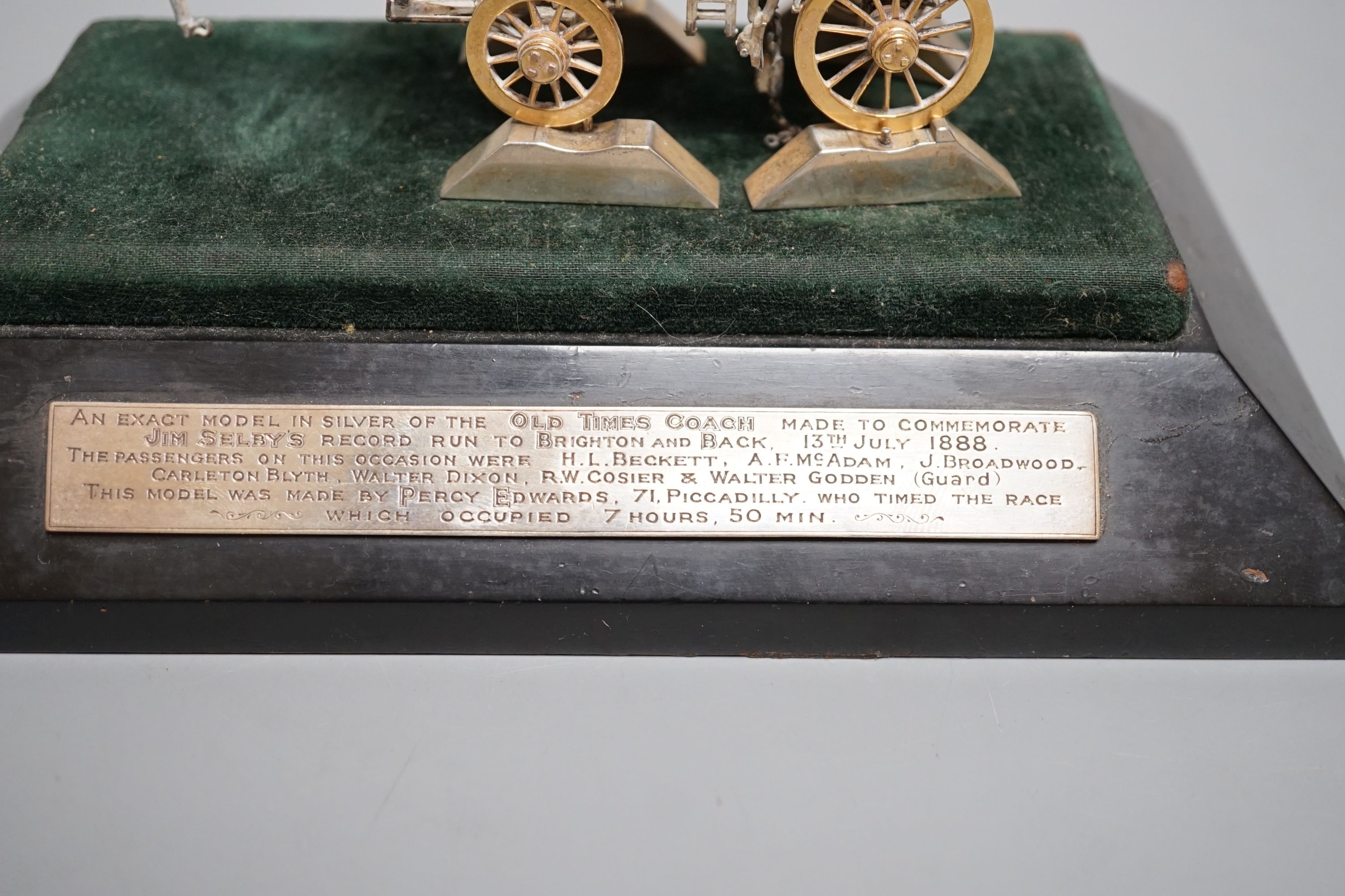 A parcel gilt white metal and enamelled miniature model of 'The Old Times Coach Made To Commemorate Jim Shelby's Record Run To Brighton and Back, 13th July, 1888', on plinth base with engraved inscription, overall 12.8cm